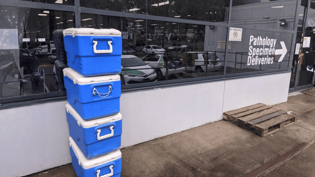 a pile of pathology sample cooler boxes waiting outside a laboratory